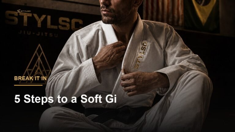 BJJ athlete sitting on mat in white Stylso gi — how to break in a BJJ gi, step-by-step guide